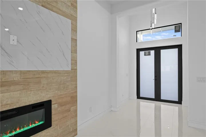 Entrance foyer with french doors and a tiled fireplace