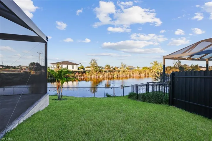View of yard with glass enclosure and a water view
