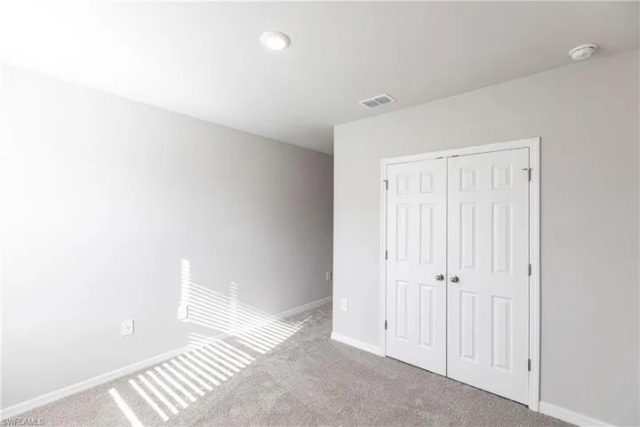 Unfurnished bedroom featuring a closet and carpet floors