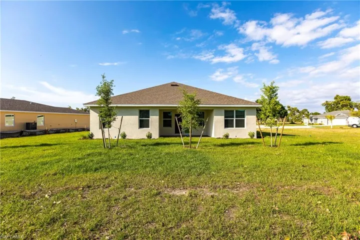 Rear view of house featuring a yard