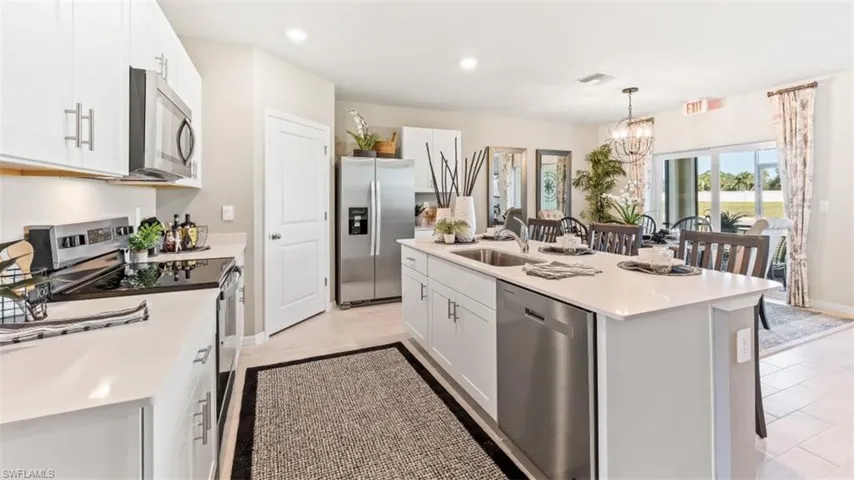 Model Home. The kitchen features white cabinetry, stainless steel appliances, and a central island with a sink and dishwasher