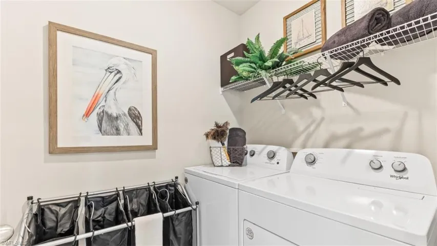 Model Home. Laundry area featuring a washer and dryer, along with wall-mounted wire shelving