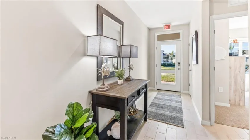 Model Home. The entryway features light-toned tiled flooring and a glass-paneled front door, allowing natural light into the space