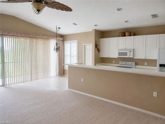 Open-concept living space featuring a vaulted ceiling and a ceiling fan