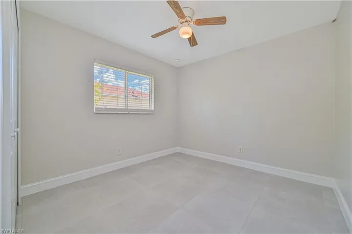Spare room featuring ceiling fan and light tile floors