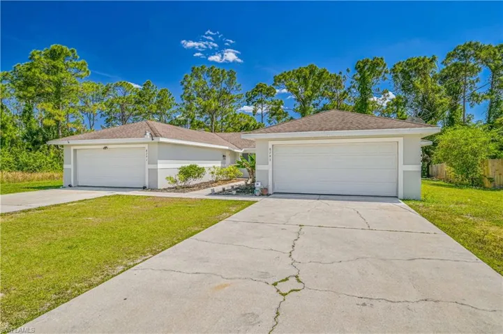 Ranch-style home featuring a garage and a front lawn