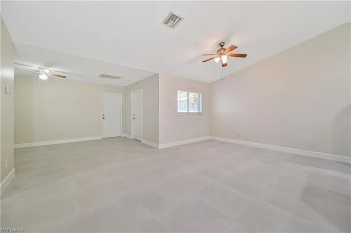 Empty room featuring ceiling fan and light tile floors