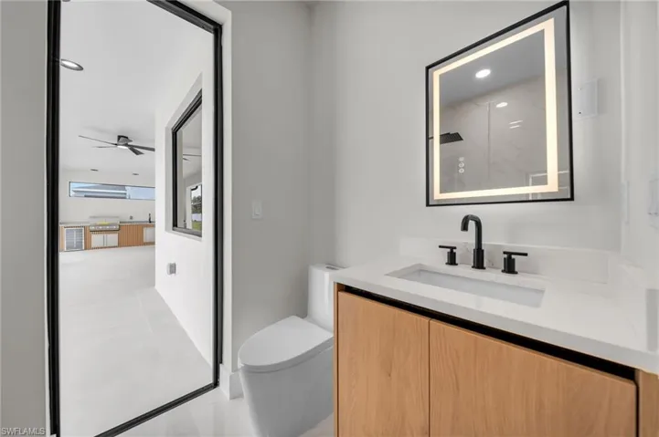 Bathroom with ceiling fan, visible vents, tile patterned flooring, vanity, and toilet