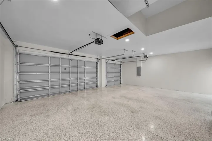 Garage featuring recessed lighting, a garage door opener, and electric panel