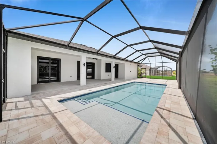 Outdoor pool with ceiling fan, a lanai, and a patio area