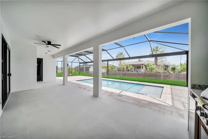 View of pool featuring ceiling fan, fence, a fenced in pool, a patio area, and a lanai