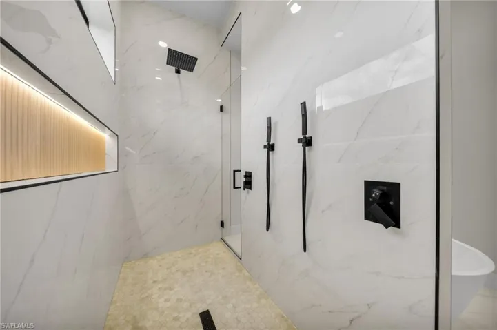 Bathroom with a marble finish shower and a soaking tub