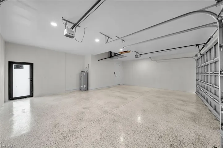 Garage featuring water heater and a garage door opener