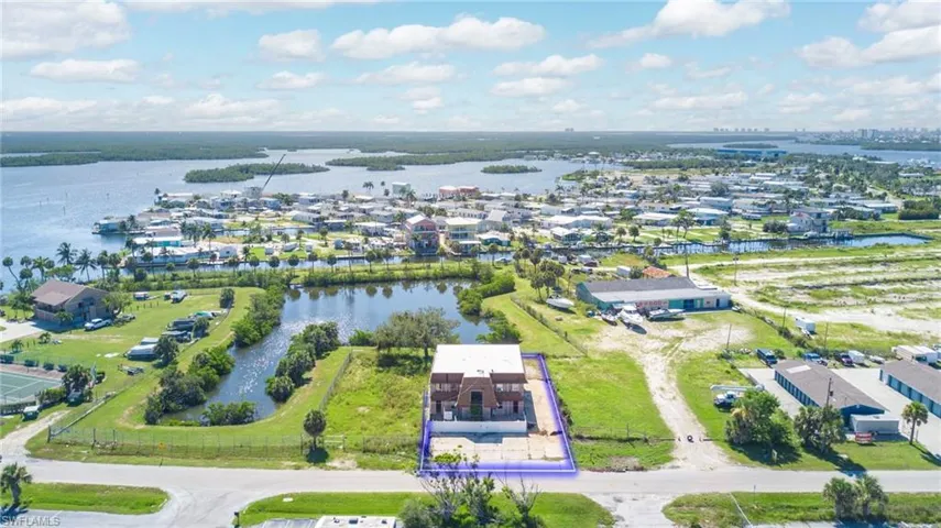 Aerial view of property's location featuring a nearby body of water and nearby suburban area