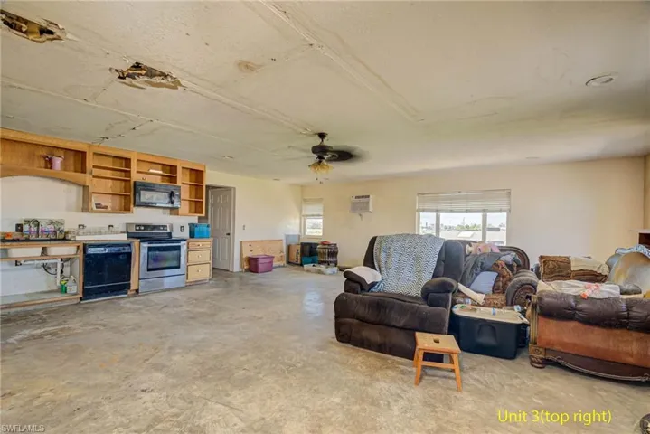 Living room featuring a ceiling fan and concrete floors