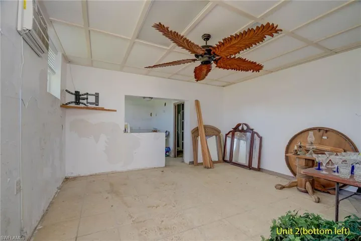 Living area with an AC wall unit and a ceiling fan