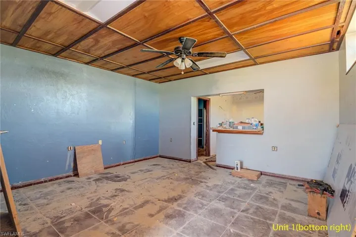 Empty room featuring a ceiling fan and baseboards