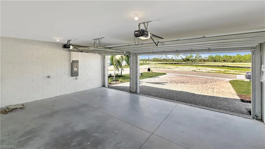 Garage featuring a garage door opener and electric panel