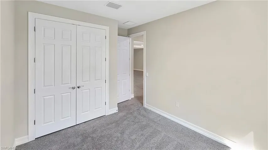 Unfurnished bedroom with a closet and light carpet