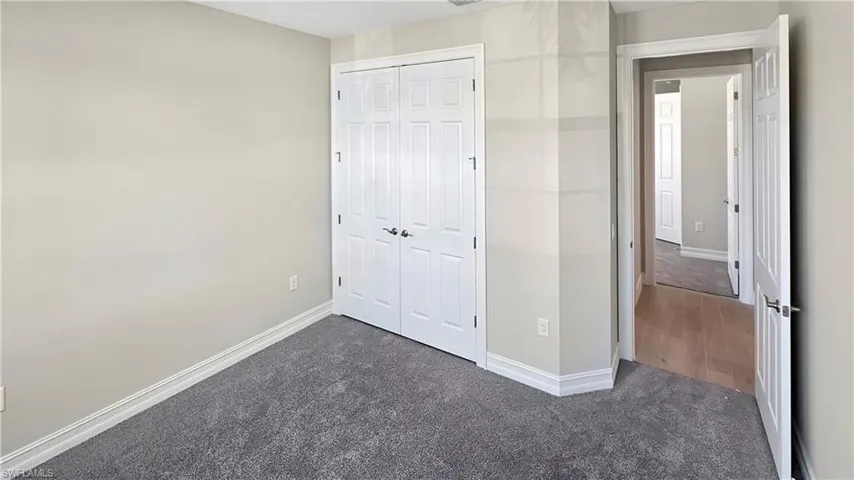 Unfurnished bedroom with a closet and carpet flooring