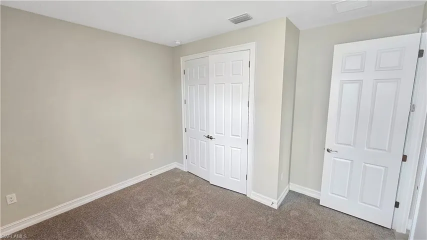 Unfurnished bedroom with carpet flooring