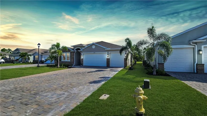 Ranch-style home with a 3 car garage and a yard