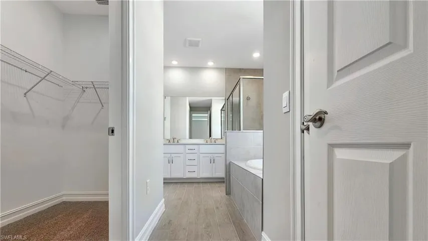 Bathroom with independent shower and bath, vanity, and hardwood / wood-style floors