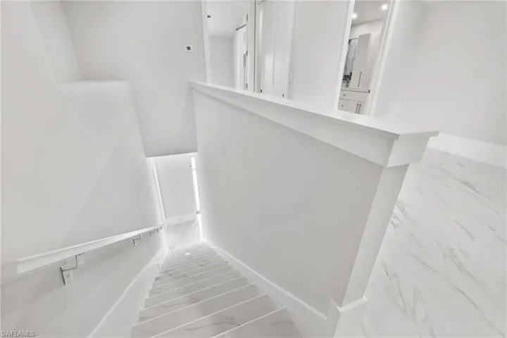 Stairway featuring marble finish floors and baseboards