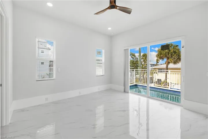 Unfurnished room featuring ceiling fan, plenty of natural light, light marble finish flooring, and recessed lighting