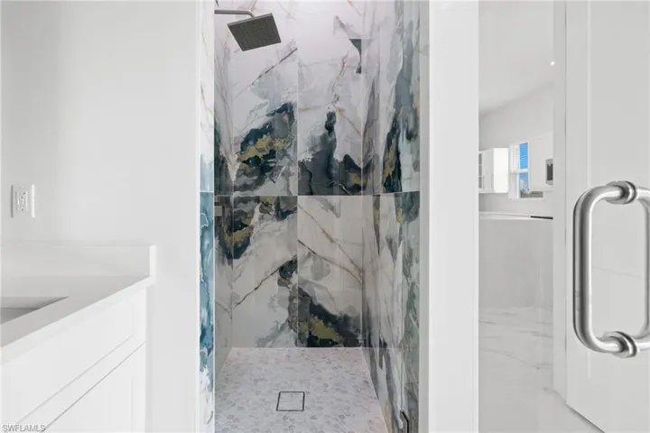 Full bathroom with a marble finish shower and vanity