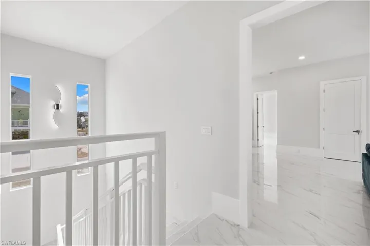 Hallway with baseboards and light marble finish floors