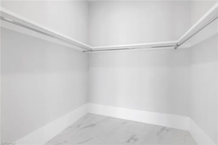 Walk in closet featuring light marble finish floors