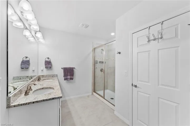 Bathroom featuring tile patterned flooring, an enclosed shower, and vanity