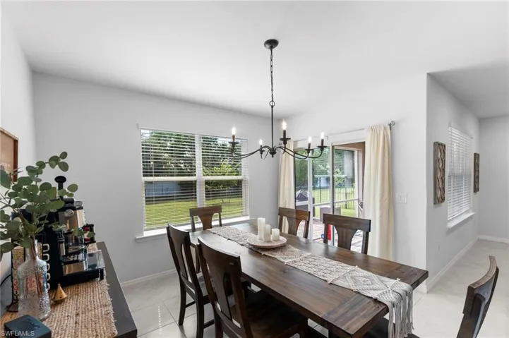 Dining area featuring light tile patterned floors, a chandelier, and a healthy amount of sunlight