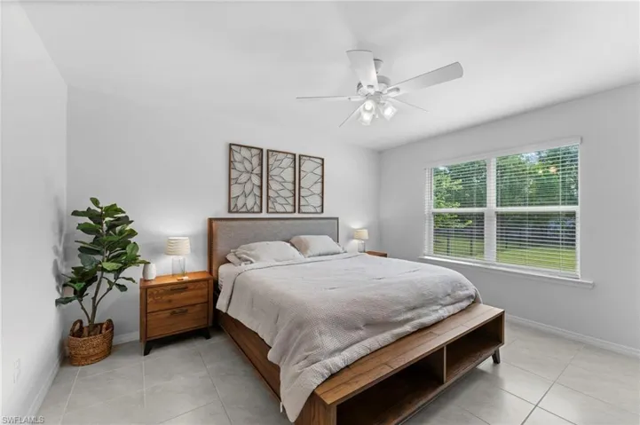 Bedroom with ceiling fan and light tile patterned floors