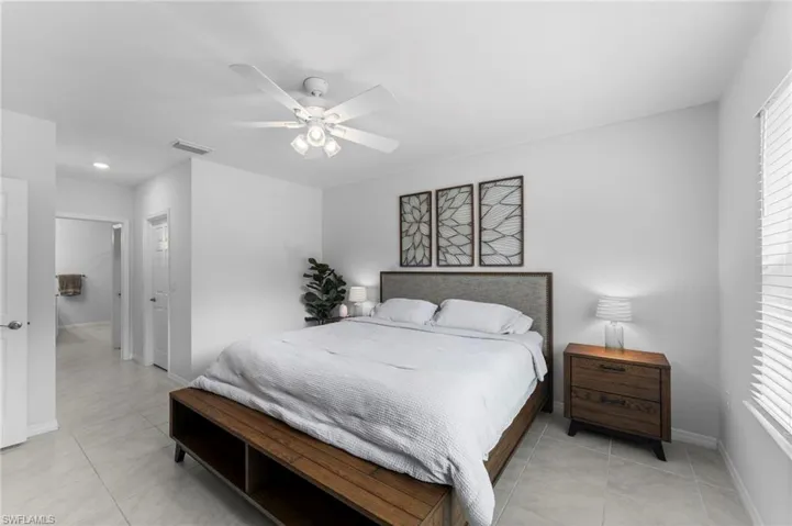 Bedroom with ceiling fan and light tile patterned floors