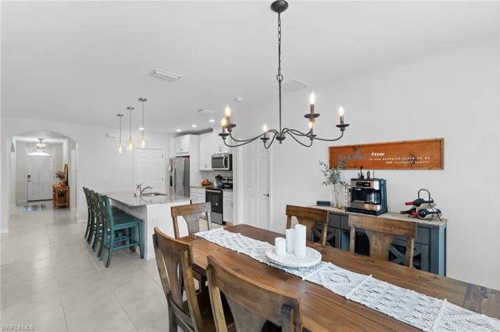 Tiled dining room featuring a chandelier