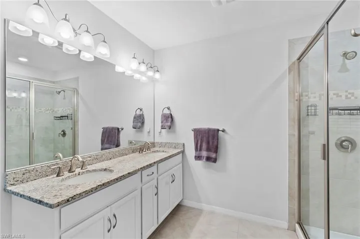 Bathroom featuring tile patterned flooring, an enclosed shower, and vanity