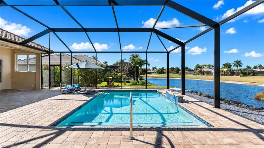 Screened lanai featuring a swimming pool, integrated spa, and paver decking
