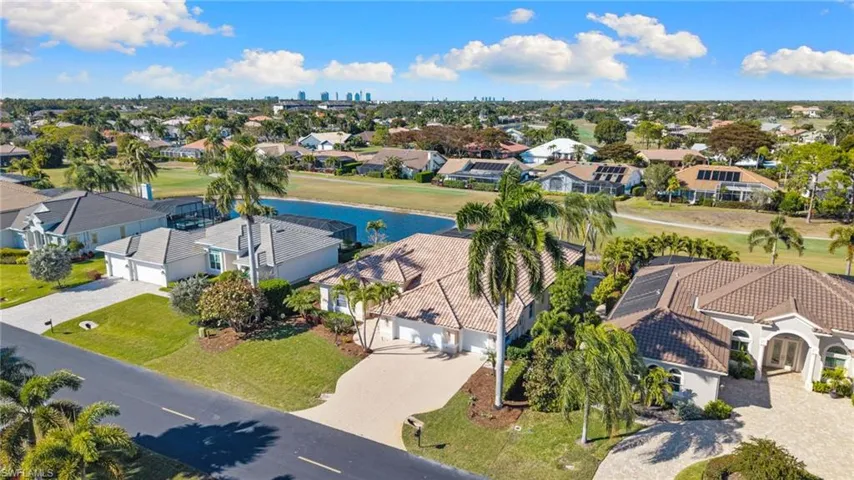 Aerial perspective of suburban area with a nearby body of water and a local golf course