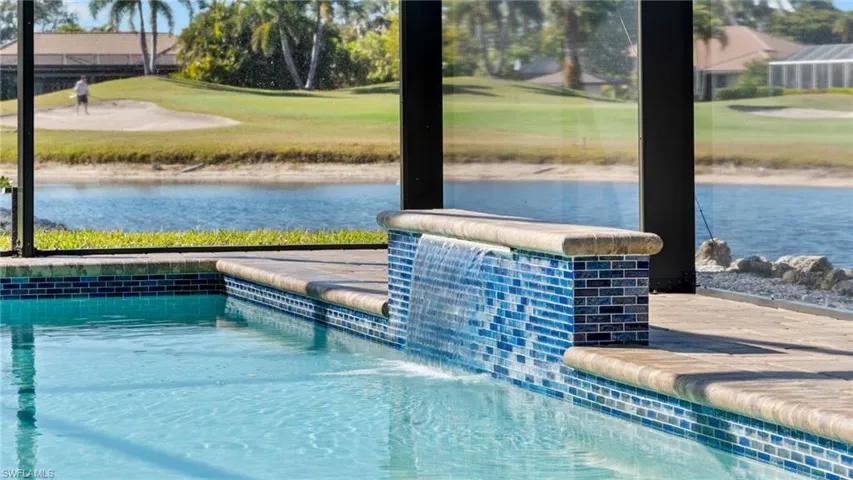 Outdoor pool featuring view of golf course, a patio, and a yard