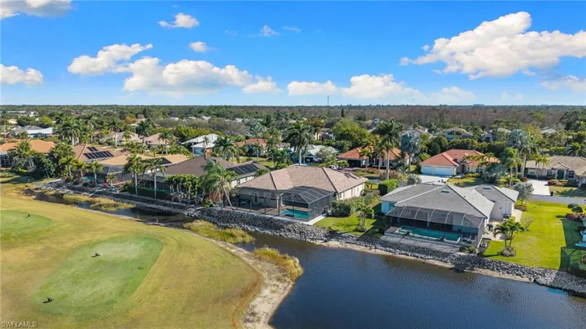 Aerial perspective of suburban area with a nearby body of water and a golf course