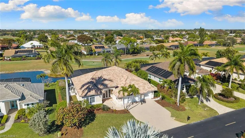 Aerial view of residential area with a nearby body of water and a golf course