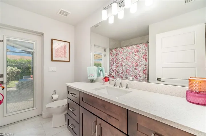Bathroom with vanity, healthy amount of natural light, light tile patterned floors, and a shower with curtain