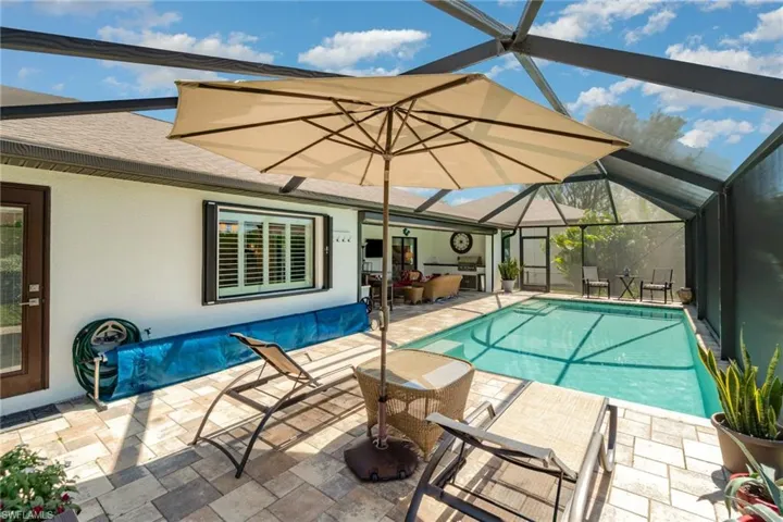 Swimming pool with a patio area, a sunroom, a lanai, and outdoor lounge area