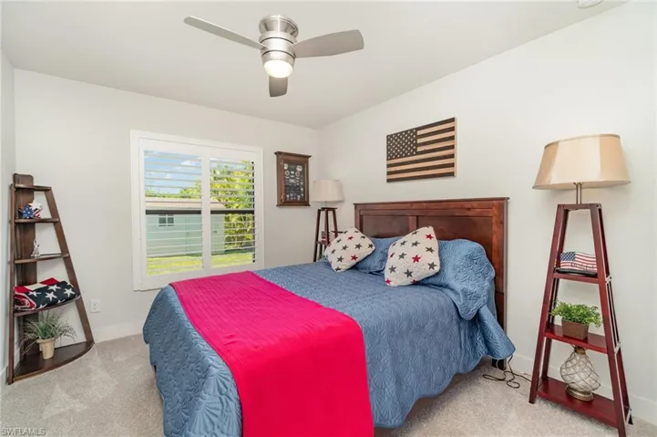 Bedroom with ceiling fan and light colored carpet