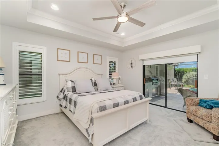 Bedroom with light carpet, a raised ceiling, recessed lighting, a ceiling fan, and ornamental molding