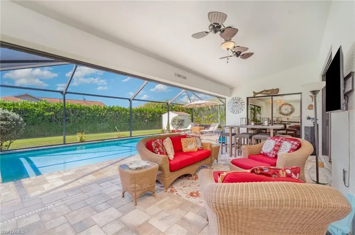 Swimming pool with a sunroom, a lanai, a patio, and an outdoor living space