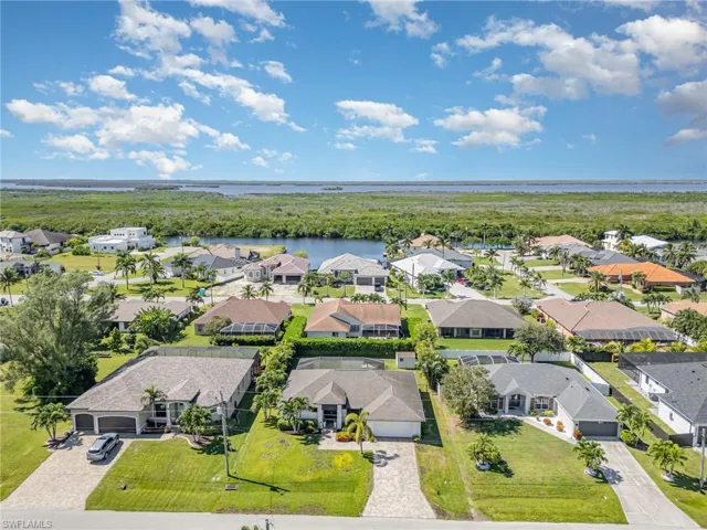 Aerial perspective of suburban area featuring a nearby body of water