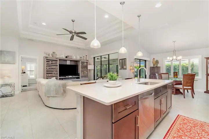 Kitchen with decorative light fixtures, dishwasher, a raised ceiling, a chandelier, and recessed lighting